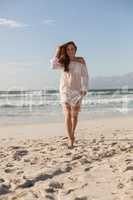 Young Caucasian beautiful young woman walking on the beach