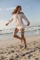 Young Caucasian woman dancing on the beach