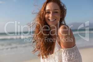 Young woman smiling at camera on the beach