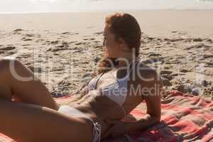 Young Caucasian woman in bikini relaxing on the beach