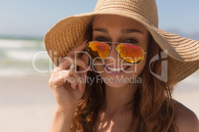 Young bikini Caucasian woman with hat looking over sunglasses