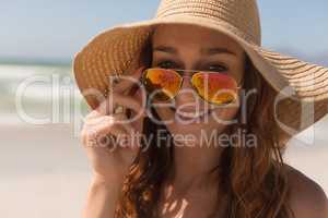 Young bikini Caucasian woman with hat looking over sunglasses