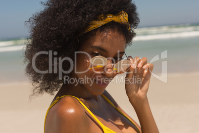 Young African American woman in bikini looking over sunglasses