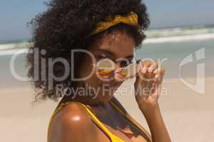 Young African American woman in bikini looking over sunglasses
