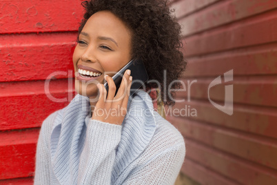 Young African American woman talking to mobile phone at beach hut
