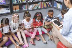 High angle view of school kids holding digital tablet like their teacher