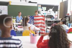Schoolboy holding an american flag in classroom