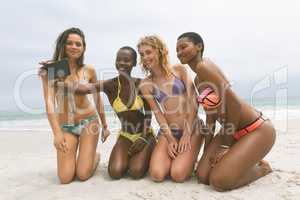 Women with bikini taking selfie on beach