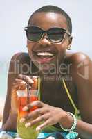 Woman lying at beach while having pineapple