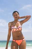 Woman posing while standing on beach on a sunny day