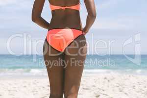 Woman posing while standing on beach on a sunny day