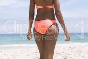 Woman posing while standing on beach on a sunny day