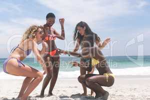 Female friends dancing on beach on a sunny day