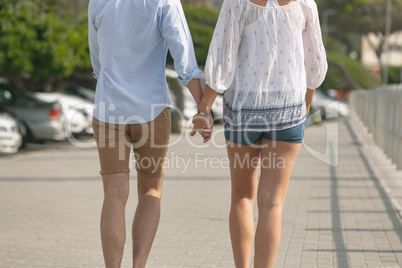Caucasian couple walking on the promenade on a sunny day