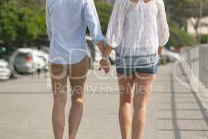 Caucasian couple walking on the promenade on a sunny day