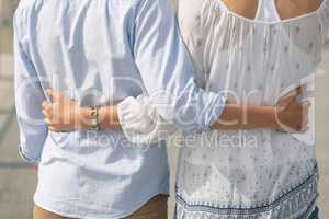 Caucasian couple  standing on the promenade with arm around on a sunny day