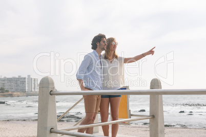 Caucasian couple interacting with each other on the promenade at the seaside