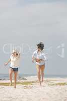 Happy Caucasian couple running  at beach on sunny day