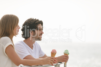 Caucasian couple standing at promenade while having ice cream cone