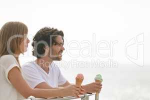 Caucasian couple standing at promenade while having ice cream cone