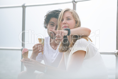 Caucasian couple siting at promenade while having ice cream cone