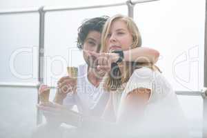 Caucasian couple siting at promenade while having ice cream cone