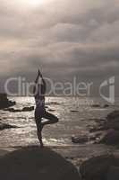 Caucasian woman perform yoga on the beach