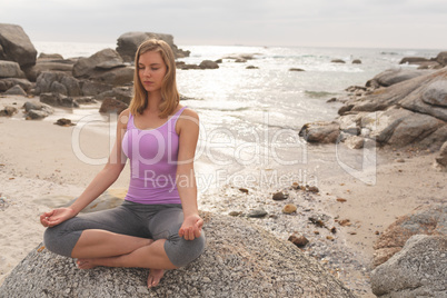 Caucasian woman perform yoga on the beach