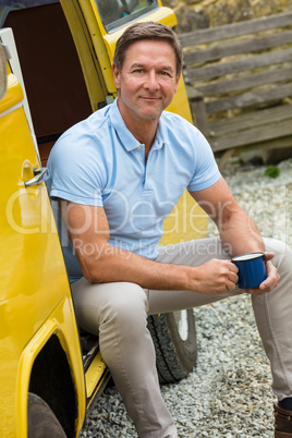 Happy Middle Aged Man Drinking Tea or Coffee Sitting In Van