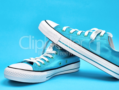 pair of blue textile sneakers with white laces,