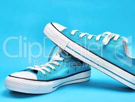 pair of blue textile sneakers with white laces,