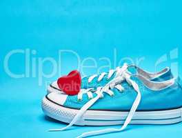 pair of blue textile sneakers with white untied laces