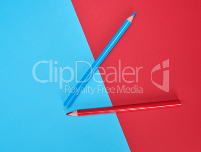 red and blue wooden pencils on color abstract background