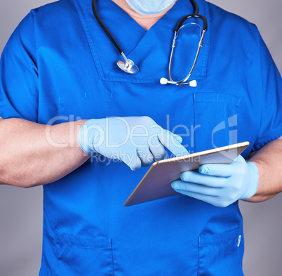 doctor in blue uniform and latex sterile gloves holding an elect
