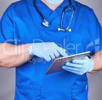 doctor in blue uniform and latex sterile gloves holding an elect