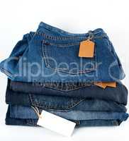 stack of folded blue jeans with empty tags