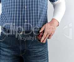 man in blue jeans and a plaid shirt shoves