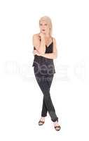 A happy looking blond woman standing in black outfit legs crosse