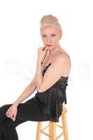 Serious looking blond woman sitting on chair