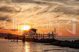 Stilt house over the sea in backlight