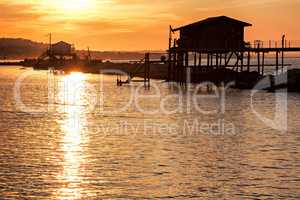 Stilt house over the sea at sunset