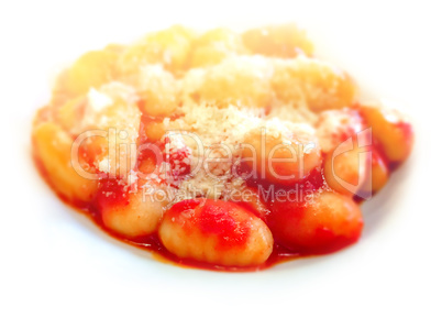 Close up view of a portion of gnocchi with tomato sauce and grated Parmesan cheese on top