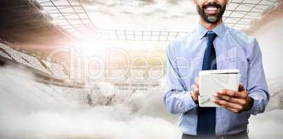 Composite image of portrait of smiling businessman using tablet computer