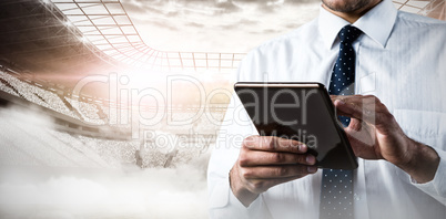 Composite image of upper mid-section of man using a tablet