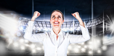 Composite image of successful businesswoman with clenched fists looking up