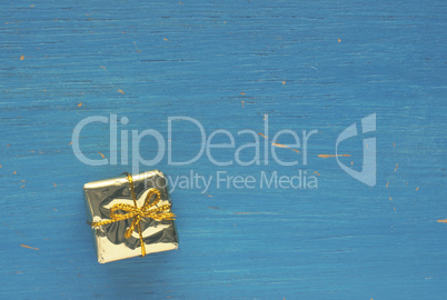 Golden gift box on blue wood