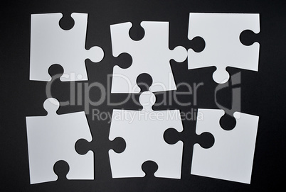 white big puzzles on a black background