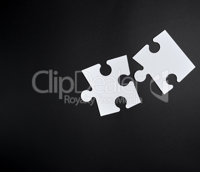 two white big puzzles on a black background