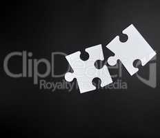 two white big puzzles on a black background