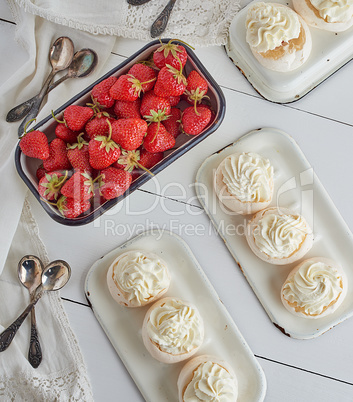 small baked round cake meringue with whipped cream and strawberr